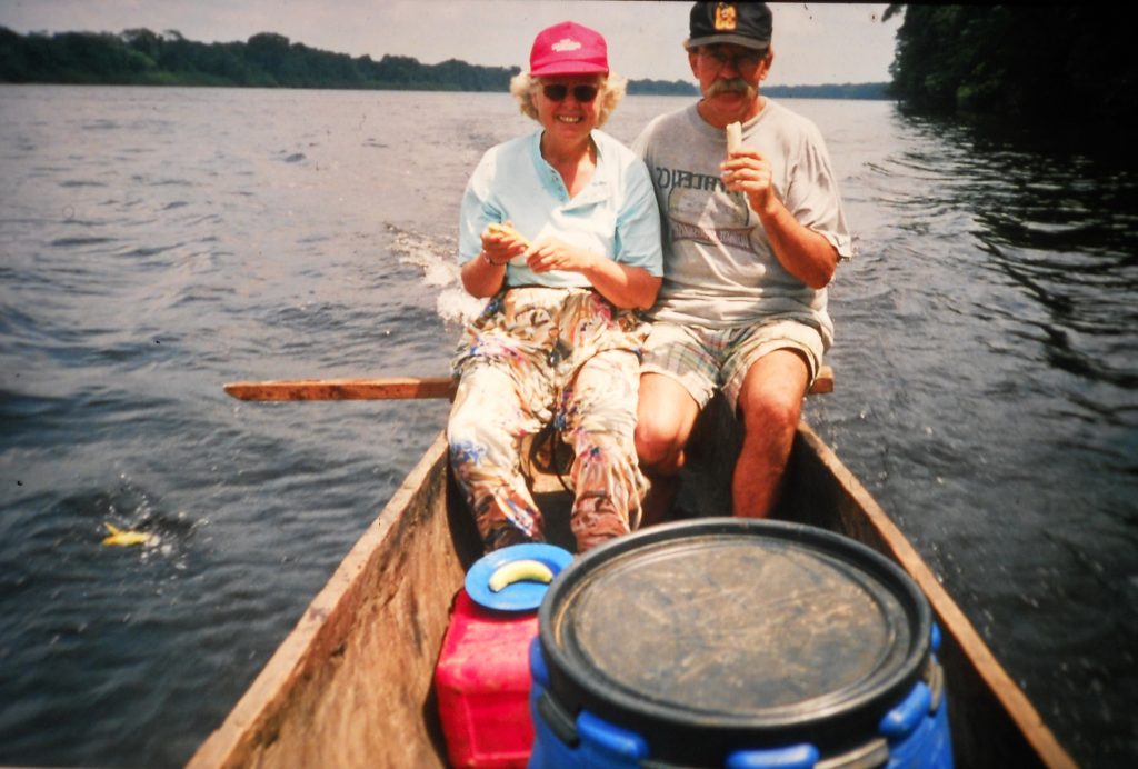 Peter und Elisabeth Gohl sitzen in einer fahrenden Piroge auf dem Fluss.